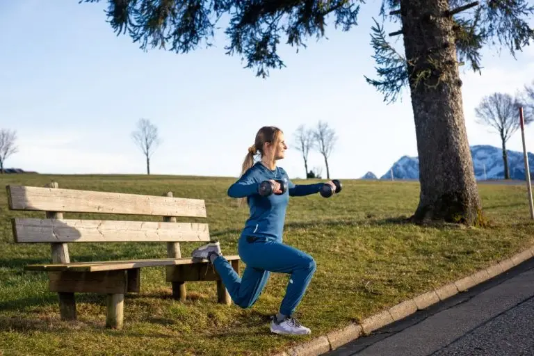 Personal Trainerin Nicola John trainiert draußen auf einer Bank