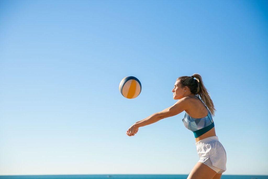 Sportliche Frau beim Beachvolleyball postpartum